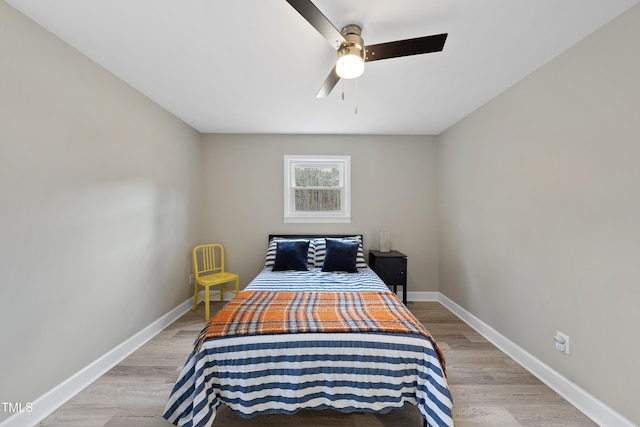 bedroom with a ceiling fan, light wood-style flooring, and baseboards