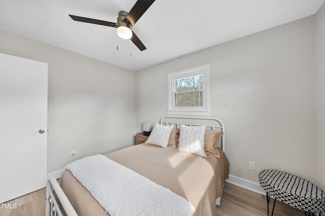 bedroom with baseboards, a ceiling fan, and light wood-style floors