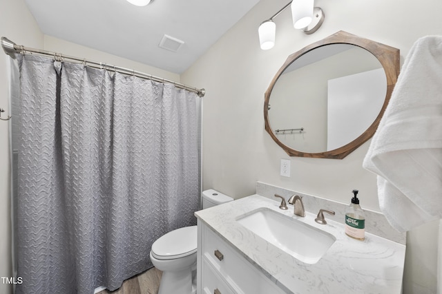 full bathroom featuring toilet, visible vents, wood finished floors, and vanity