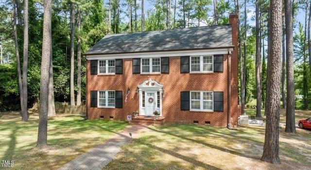 colonial inspired home with brick siding, fence, crawl space, a front lawn, and a chimney