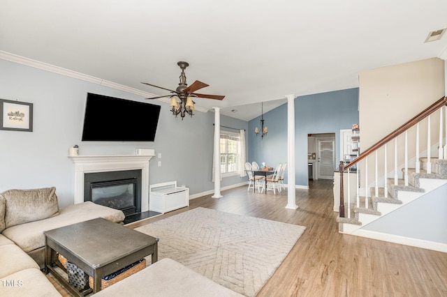 living area with visible vents, stairway, ceiling fan, wood finished floors, and baseboards