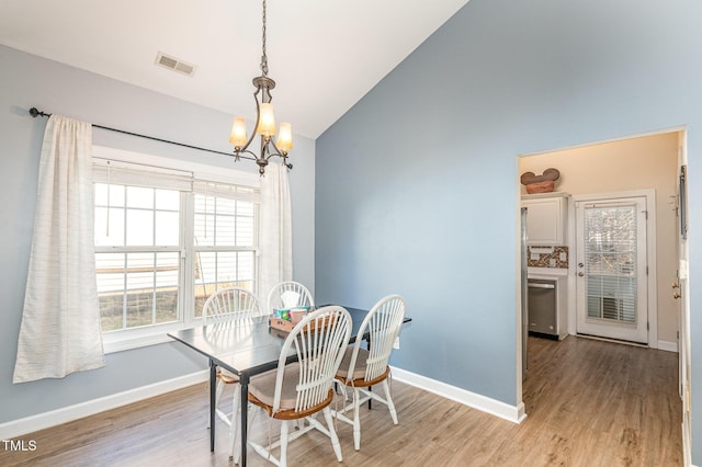 dining space featuring vaulted ceiling, baseboards, visible vents, and light wood-style floors