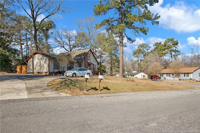 view of front facade featuring driveway and a front yard