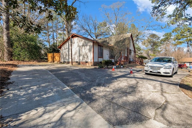 view of side of home featuring crawl space and concrete driveway