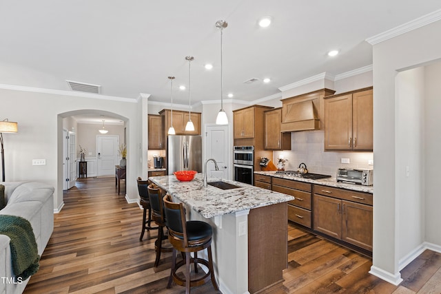 kitchen with arched walkways, a toaster, a sink, visible vents, and appliances with stainless steel finishes