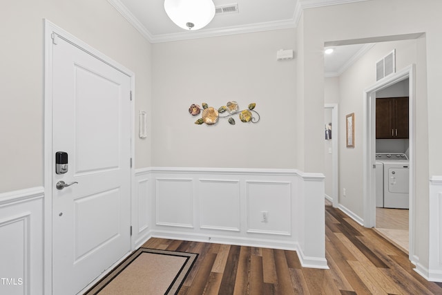 entryway with dark wood-style floors, ornamental molding, washing machine and dryer, and visible vents