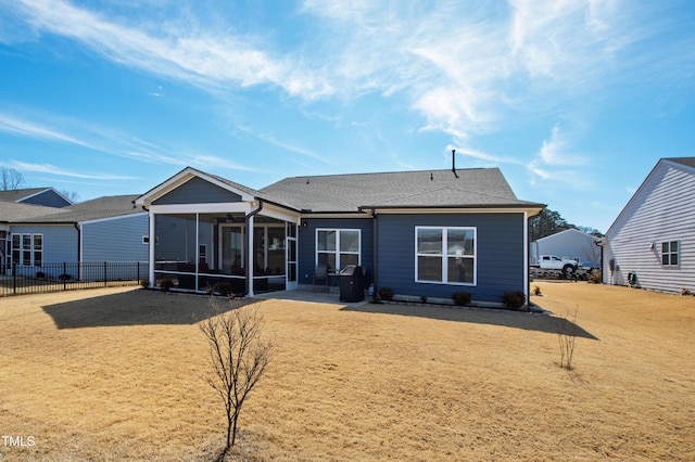 back of house with a sunroom, fence, and a lawn