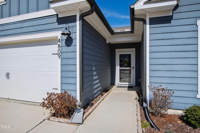 doorway to property featuring board and batten siding and an attached garage