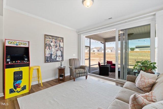 living area featuring visible vents, baseboards, crown molding, and wood finished floors