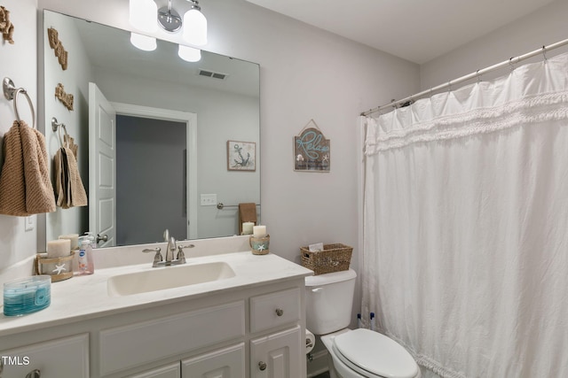 full bathroom featuring toilet, vanity, and visible vents