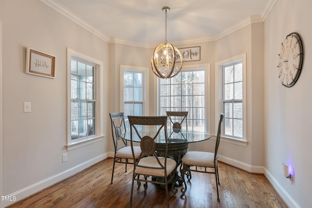 dining area with crown molding, baseboards, and wood finished floors