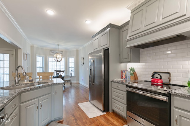 kitchen featuring gray cabinetry, a sink, appliances with stainless steel finishes, custom exhaust hood, and crown molding