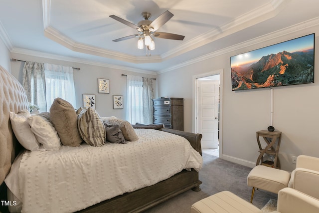 bedroom with baseboards, a raised ceiling, ceiling fan, ornamental molding, and dark carpet