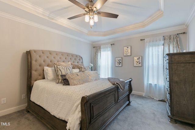 carpeted bedroom featuring ornamental molding, a raised ceiling, a ceiling fan, and baseboards