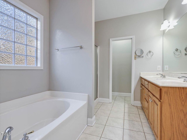 bathroom featuring double vanity, a stall shower, a bath, tile patterned floors, and a sink