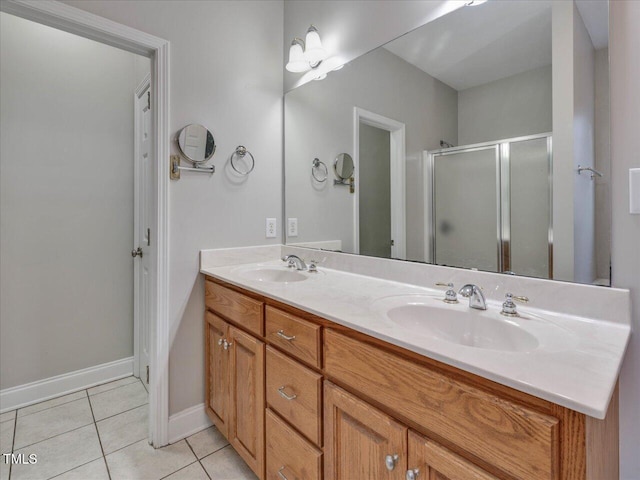 bathroom featuring a sink, double vanity, a shower stall, and tile patterned flooring