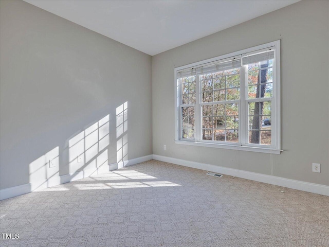 unfurnished room featuring visible vents, carpet floors, and baseboards