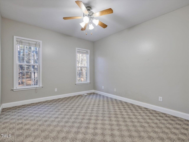 carpeted empty room featuring baseboards and ceiling fan