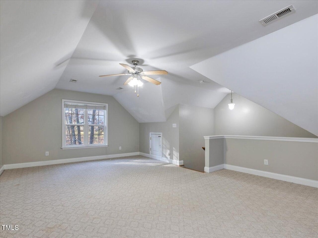 additional living space with carpet, vaulted ceiling, baseboards, and visible vents