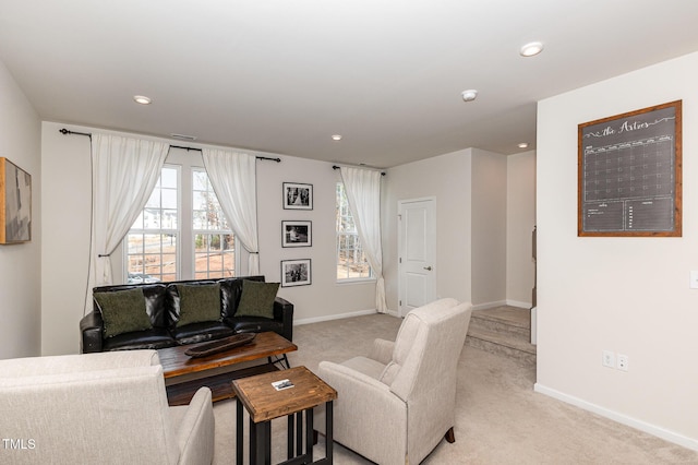 living room with a wealth of natural light, light carpet, and baseboards