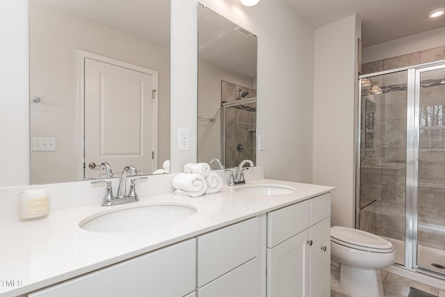 bathroom featuring a sink, toilet, and a shower stall