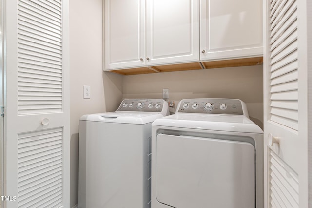 clothes washing area with cabinet space and washer and clothes dryer