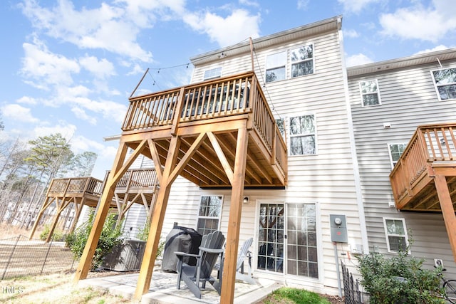 back of house with a patio, a wooden deck, and fence