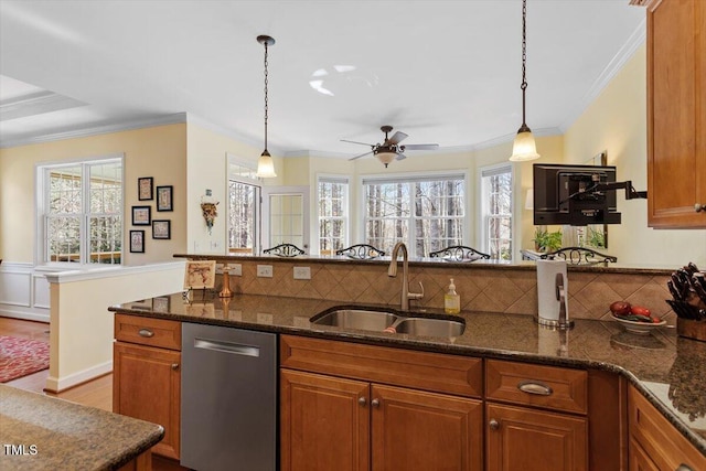 kitchen with dishwasher, brown cabinetry, and a sink