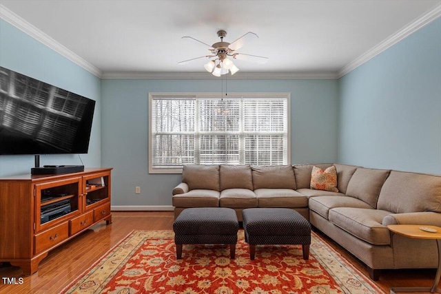 living room featuring ornamental molding, ceiling fan, baseboards, and wood finished floors