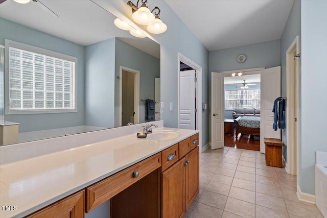 ensuite bathroom with ensuite bathroom, tile patterned flooring, vanity, and baseboards