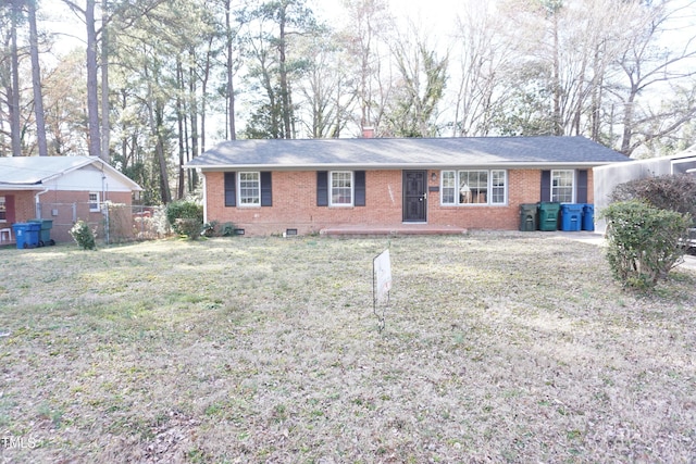 ranch-style house featuring a front yard, brick siding, fence, and a chimney