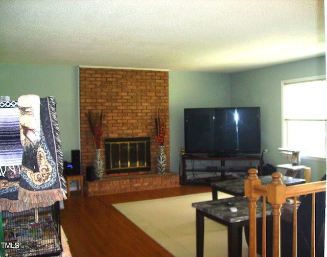 living area with a textured ceiling and a brick fireplace