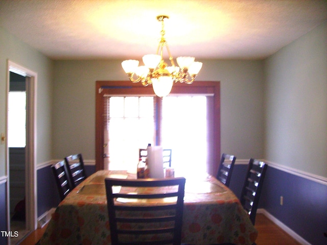 dining space featuring baseboards and a notable chandelier