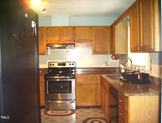 kitchen featuring electric range, dishwasher, brown cabinets, under cabinet range hood, and a sink