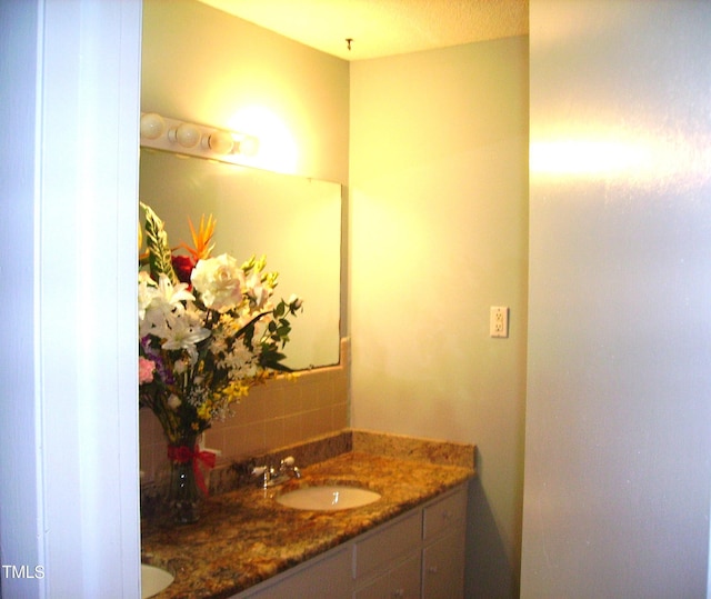 bathroom with a sink, decorative backsplash, and double vanity