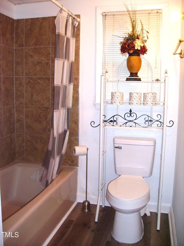 bathroom featuring baseboards, shower / tub combo with curtain, toilet, and wood finished floors