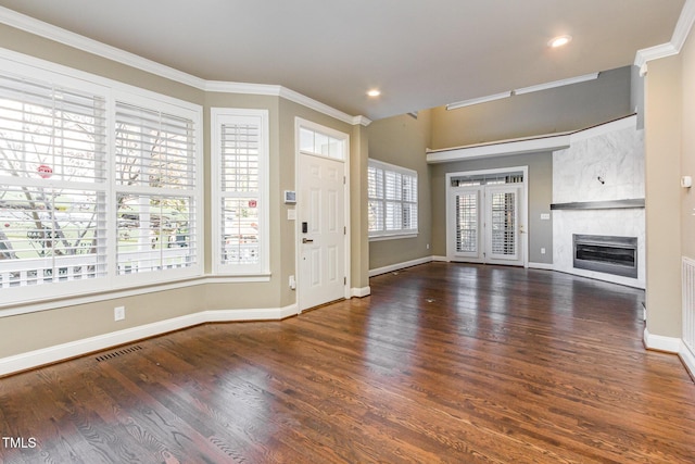 unfurnished living room featuring crown molding, visible vents, wood finished floors, and a tile fireplace