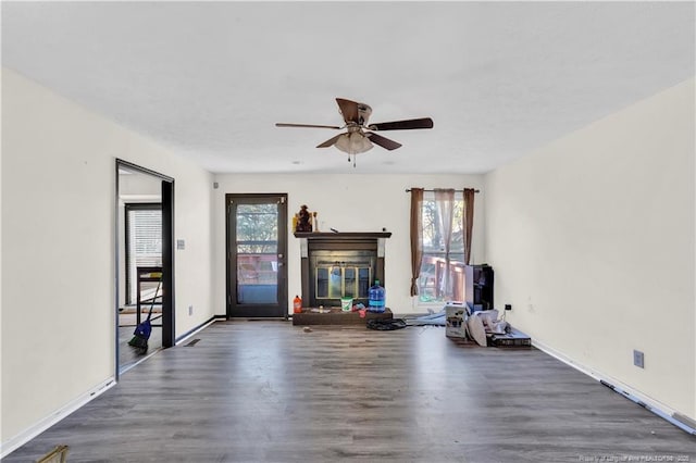 unfurnished living room with plenty of natural light, wood finished floors, and a glass covered fireplace