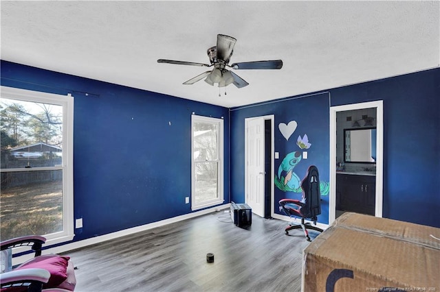 office area with ceiling fan, a textured ceiling, baseboards, and wood finished floors