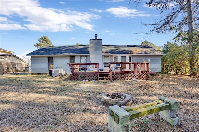 back of property with an outdoor fire pit, a chimney, crawl space, a deck, and central air condition unit