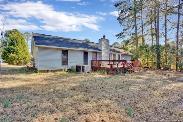 rear view of house featuring a chimney, a deck, and cooling unit