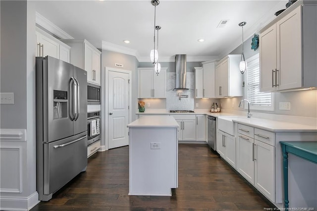 kitchen featuring crown molding, stainless steel appliances, visible vents, a kitchen island, and wall chimney range hood