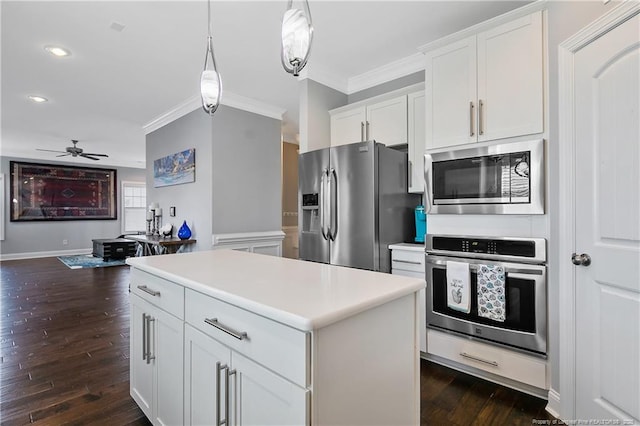 kitchen with stainless steel appliances, dark wood-style flooring, a kitchen island, white cabinetry, and ornamental molding