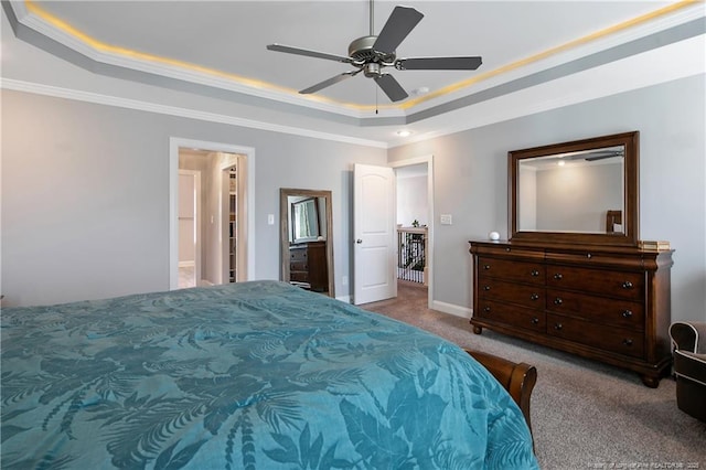 carpeted bedroom featuring ceiling fan, baseboards, a raised ceiling, and crown molding