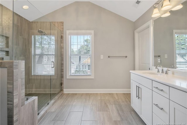 full bathroom featuring lofted ceiling, a shower stall, and vanity