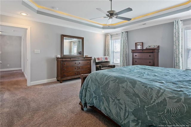 carpeted bedroom with a ceiling fan, a raised ceiling, crown molding, and baseboards