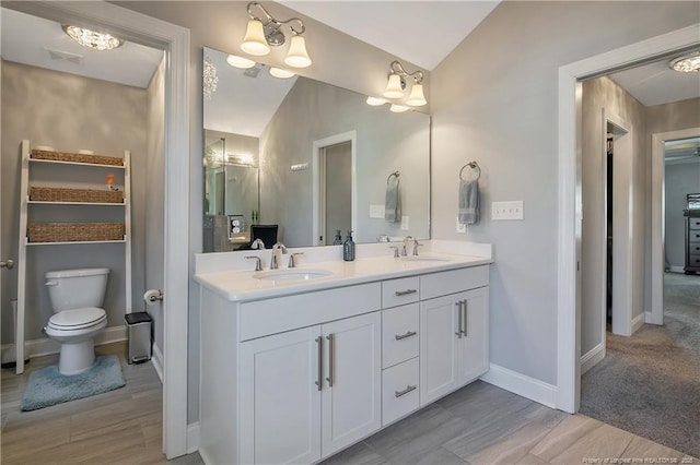 bathroom featuring double vanity, a sink, visible vents, and baseboards