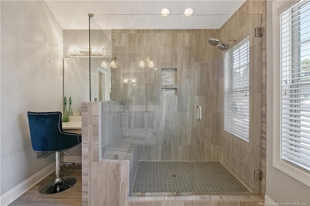 full bathroom with a shower stall and baseboards