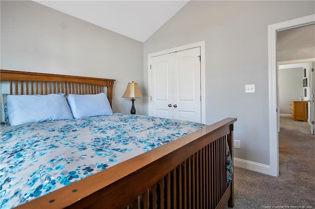 carpeted bedroom with lofted ceiling, a closet, and baseboards