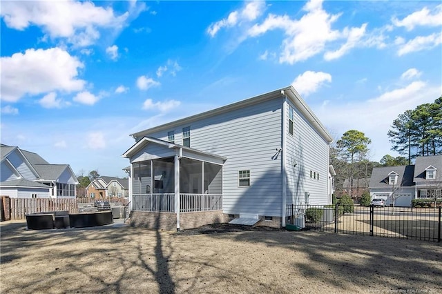 rear view of property with a residential view, a sunroom, and fence